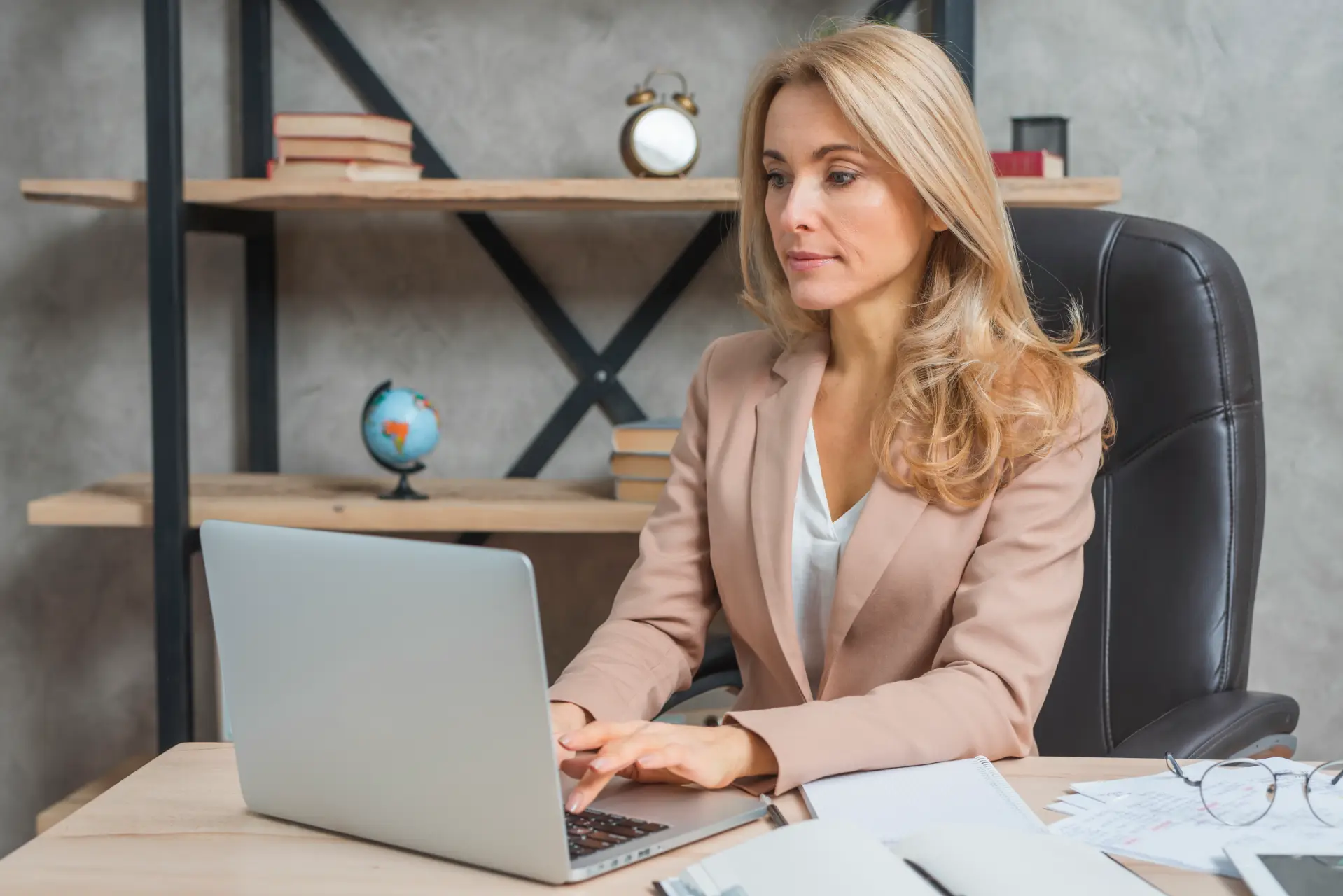 Professional woman working at a desk with a laptop in an office setting